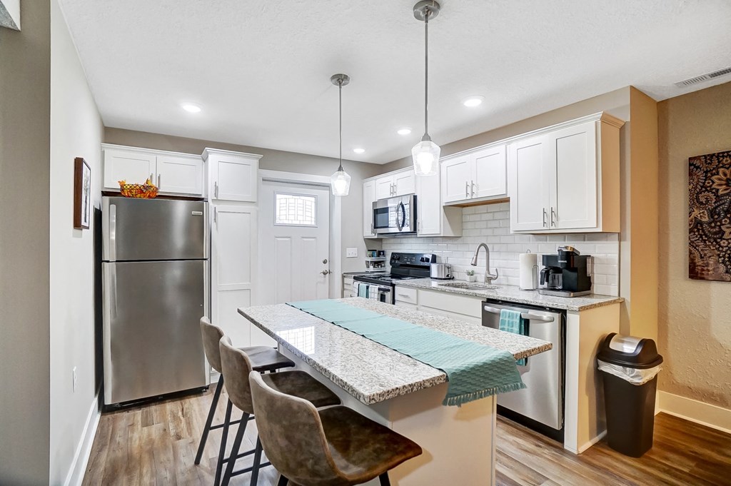 a kitchen with stainless steel appliances and a table with chairs