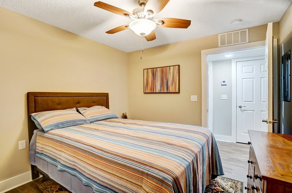 a bedroom with a bed and a ceiling fan