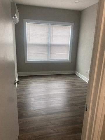 a empty room with a window and wooden floors