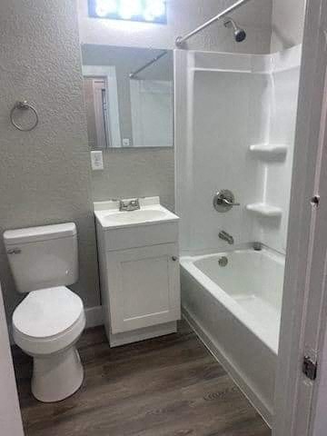 a bathroom with a toilet and a tub and a sink