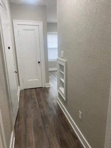 a hallway with a white door and a wooden floor