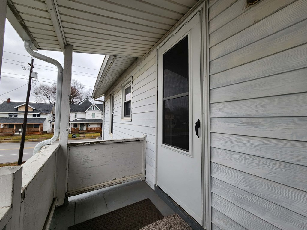 the front porch of a white house with a white door