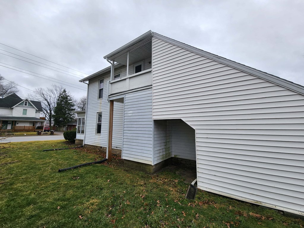 the side of a white house with a garage door open