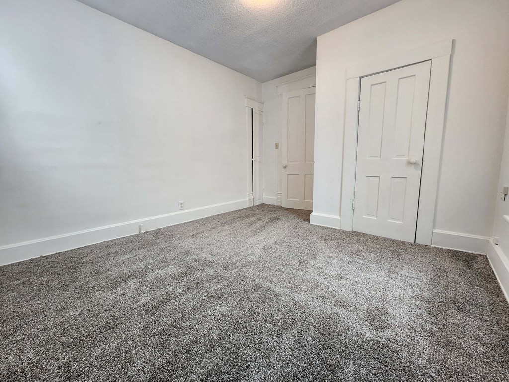a bedroom with a carpeted floor and a white door