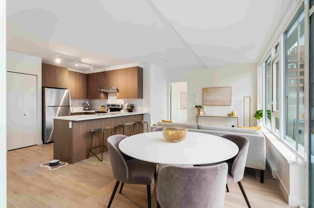 A modern kitchen with a dining table and chairs.