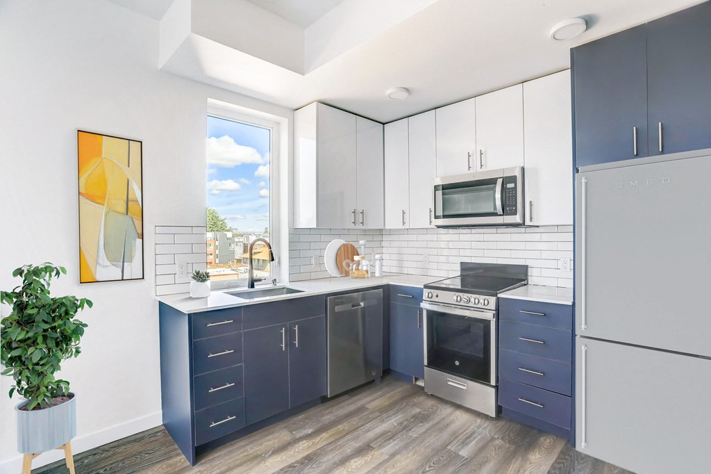 a modern kitchen with blue cabinets and a window