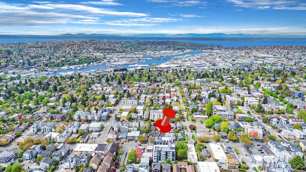 an aerial view of a city with a red arrow pointing to a suburb