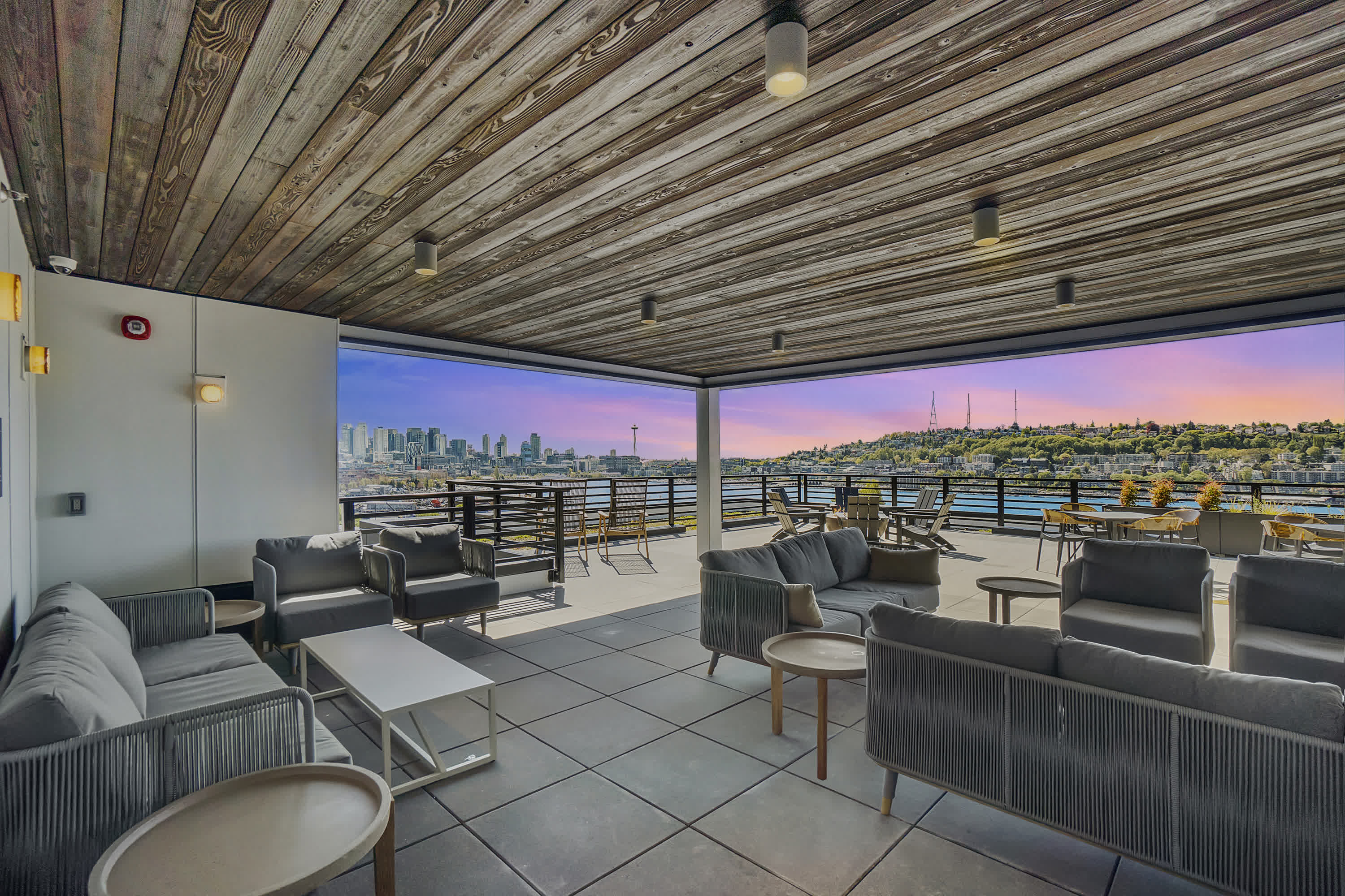 a lounge area with couches and tables and a view of the city