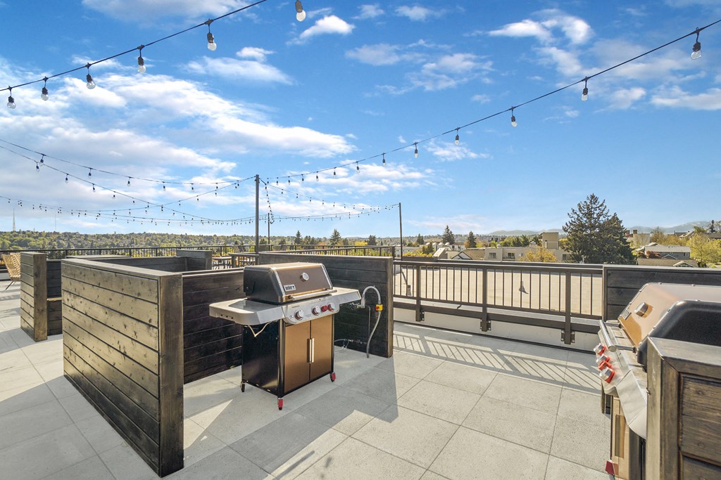 a patio with a grill and a deck with a view