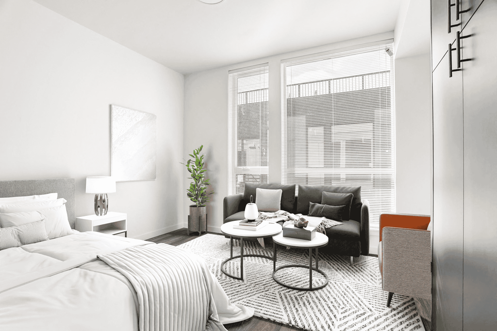 a bedroom with a bed and a couch and a large window