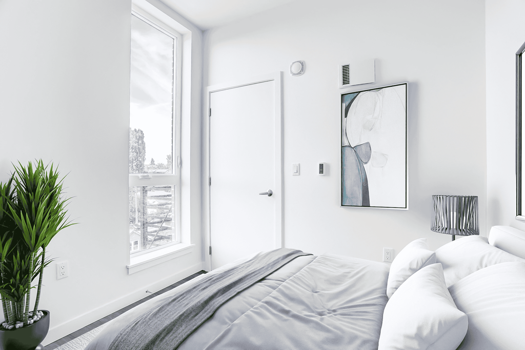 a white bedroom with a bed and a window