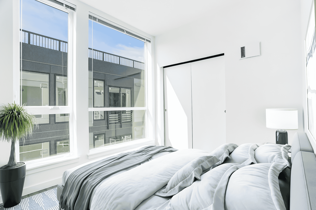 a bedroom with a large window and a bed