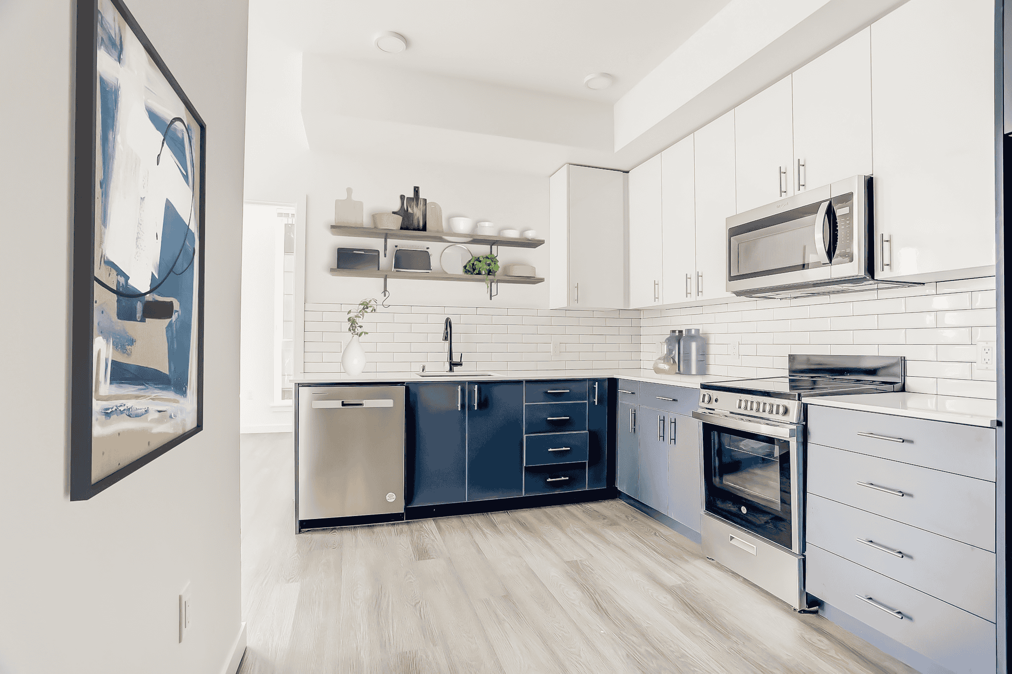 a white and blue kitchen with stainless steel appliances and white cabinets