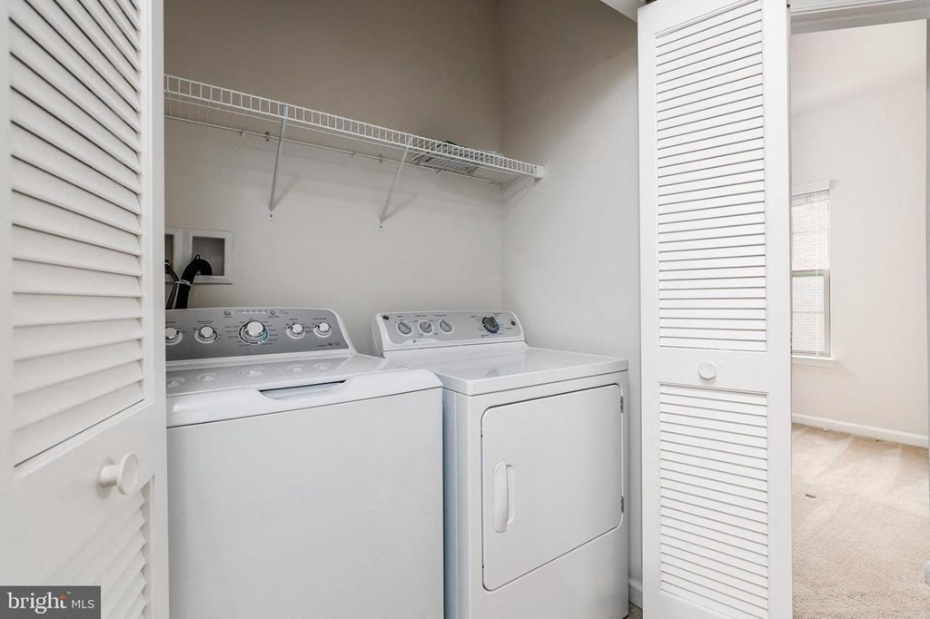 an empty laundry room with two washes and a dryer