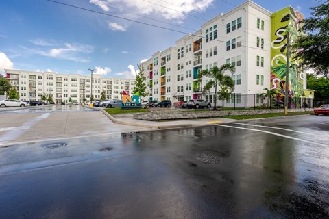 an empty street in front of an apartment building with graffiti on it