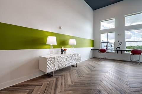 a room with a table with two lamps and a green and white wall