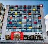 the facade of a building with many windows and a red door