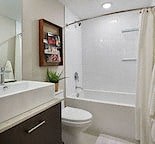 a bathroom with a toilet and a shower and a sink