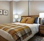 a bedroom with a bed and two lamps