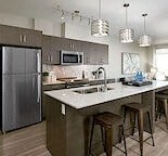 a kitchen with an island and a stainless steel refrigerator
