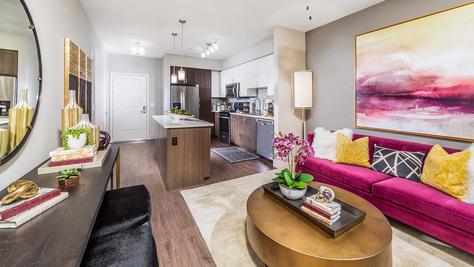 a living room and kitchen with a pink couch