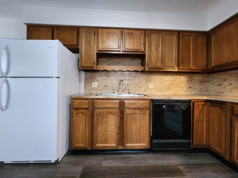 a kitchen with wooden cabinets and a refrigerator