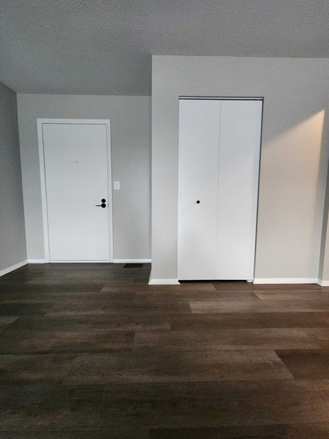 a living room with white walls and two doors