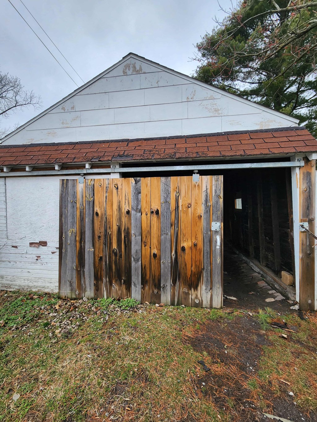 a large wooden barn door in front of a white building