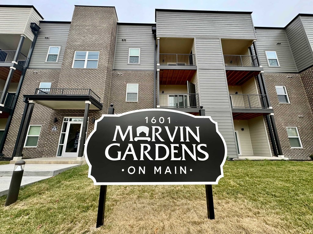 an apartment building with a yard sign in front of it