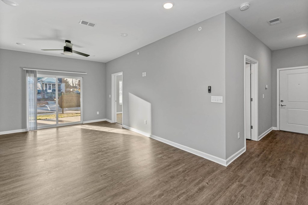 the living room is empty and has a door to the patio
