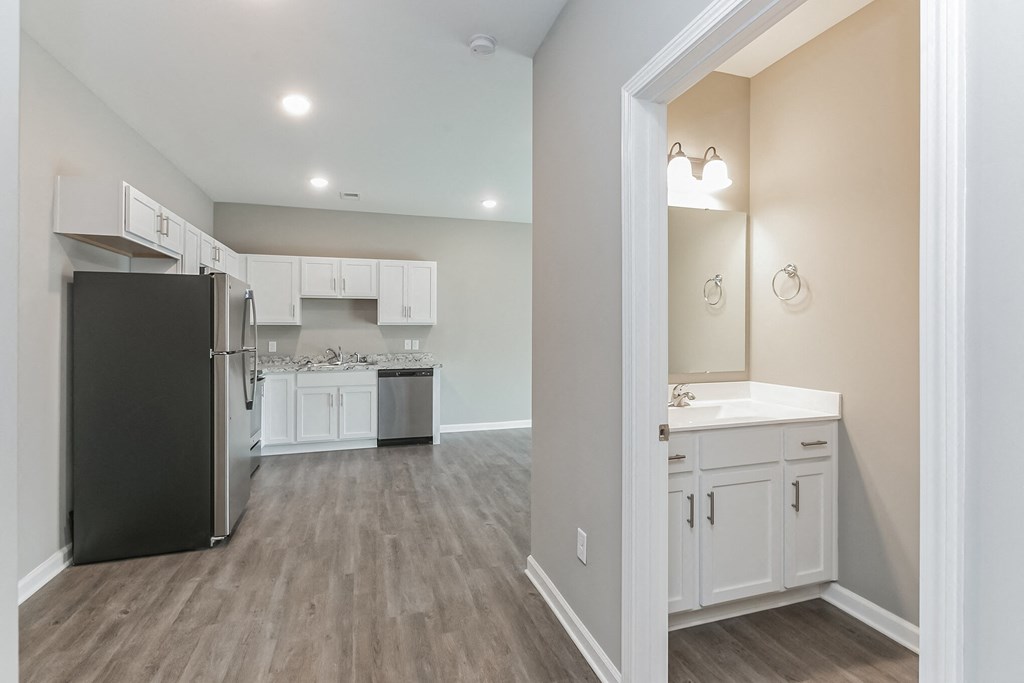 a renovated kitchen with white cabinets and a stainless steel refrigerator