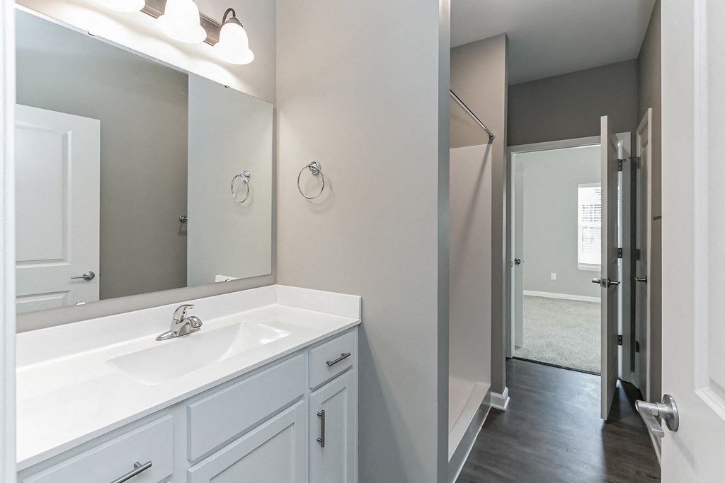 an empty bathroom with a large mirror and a sink