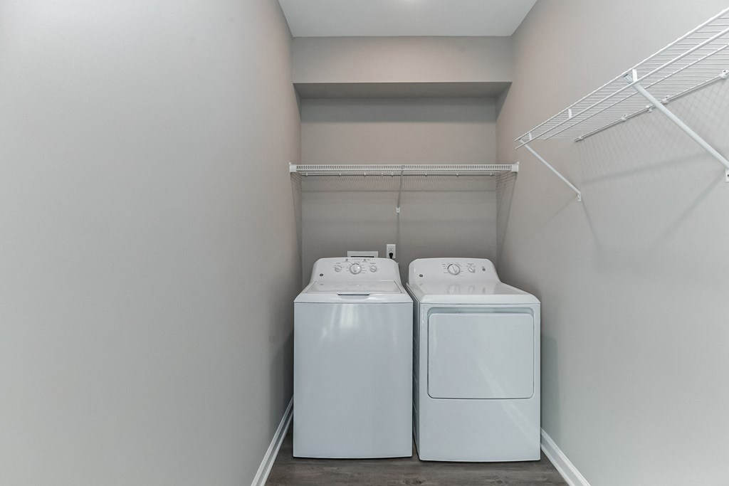 two washer and dryers in a laundry room with white walls