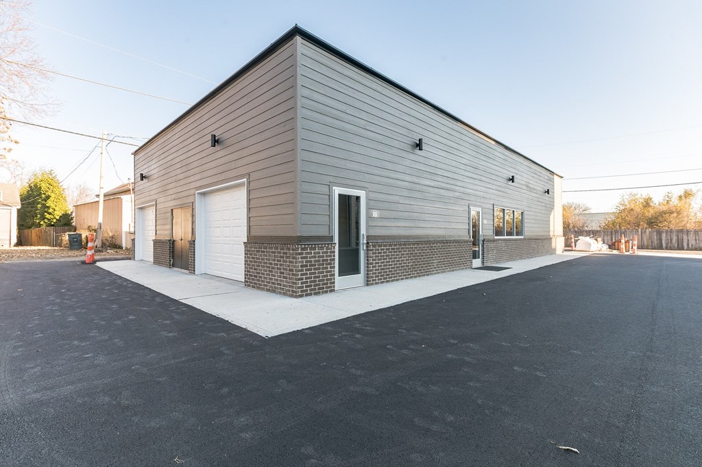 the front of a building with two garage doors
