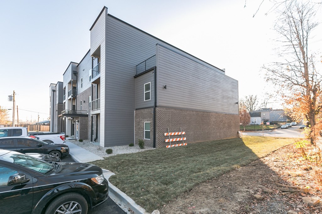 an apartment building with cars parked in front of it