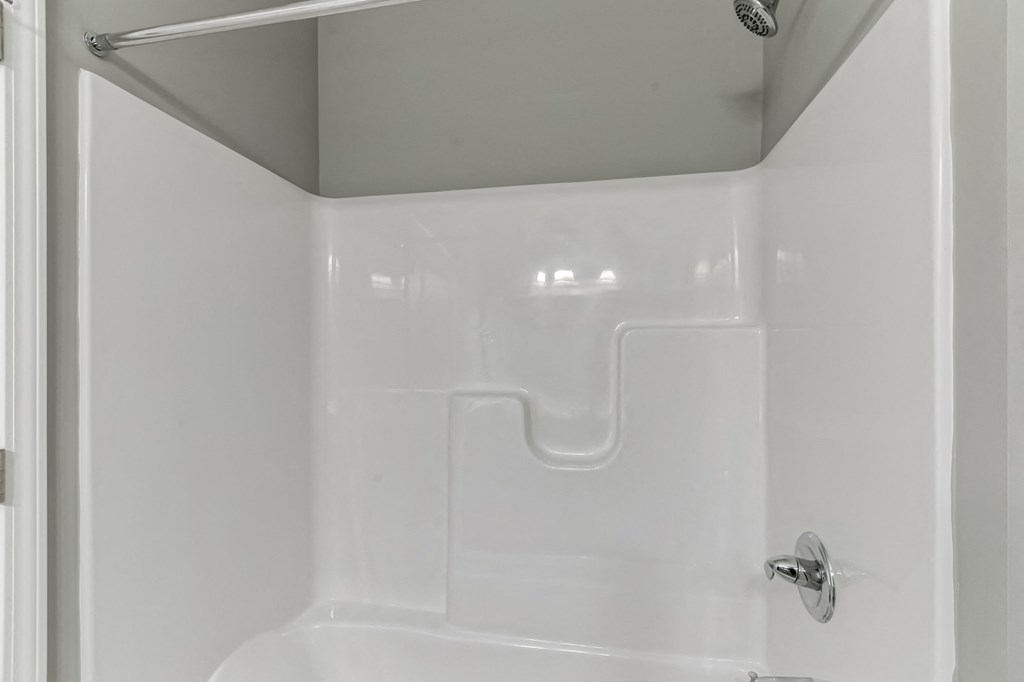 a white bathroom with a shower and a sink