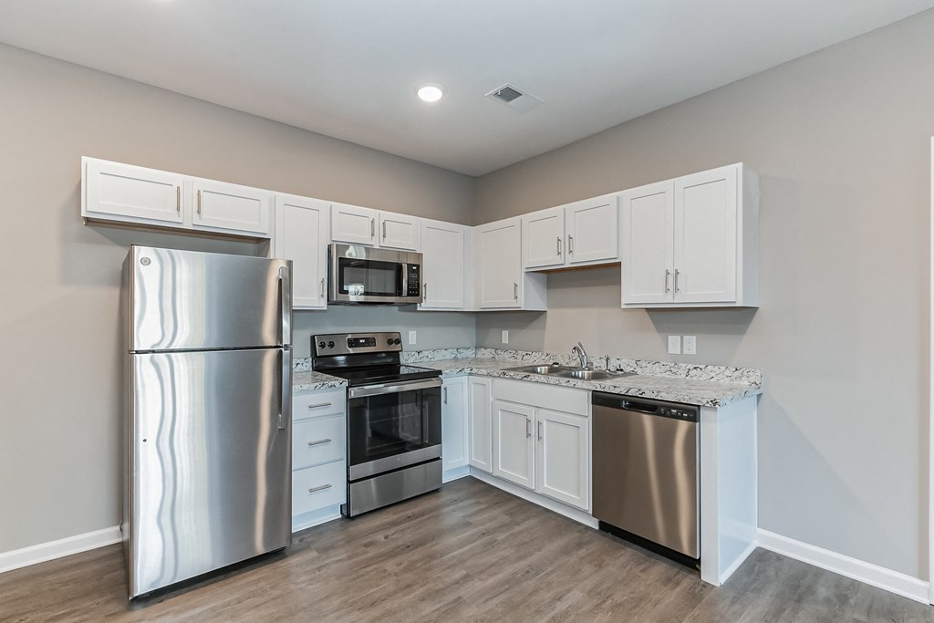 a kitchen with stainless steel appliances and white cabinets