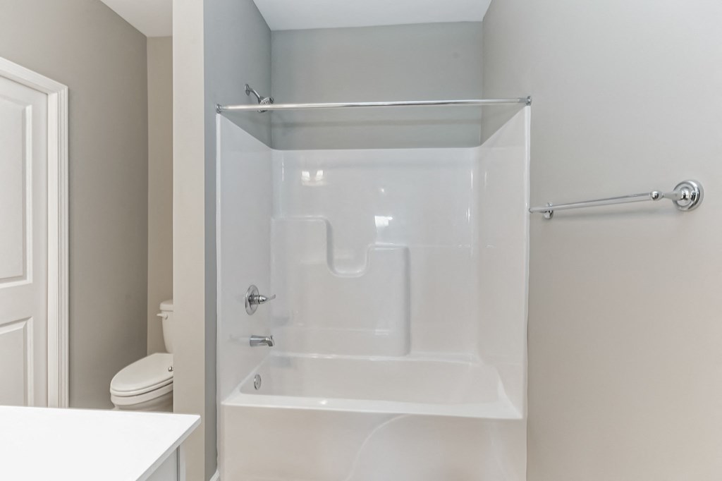 a white bathroom with a shower and a toilet