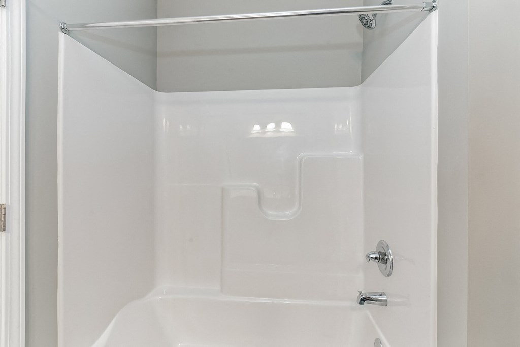 a small bathroom with a shower and a white tub