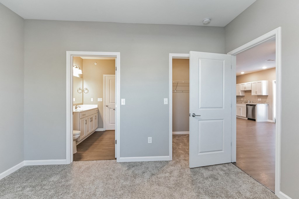 a living room with a door open to a bathroom and a kitchen