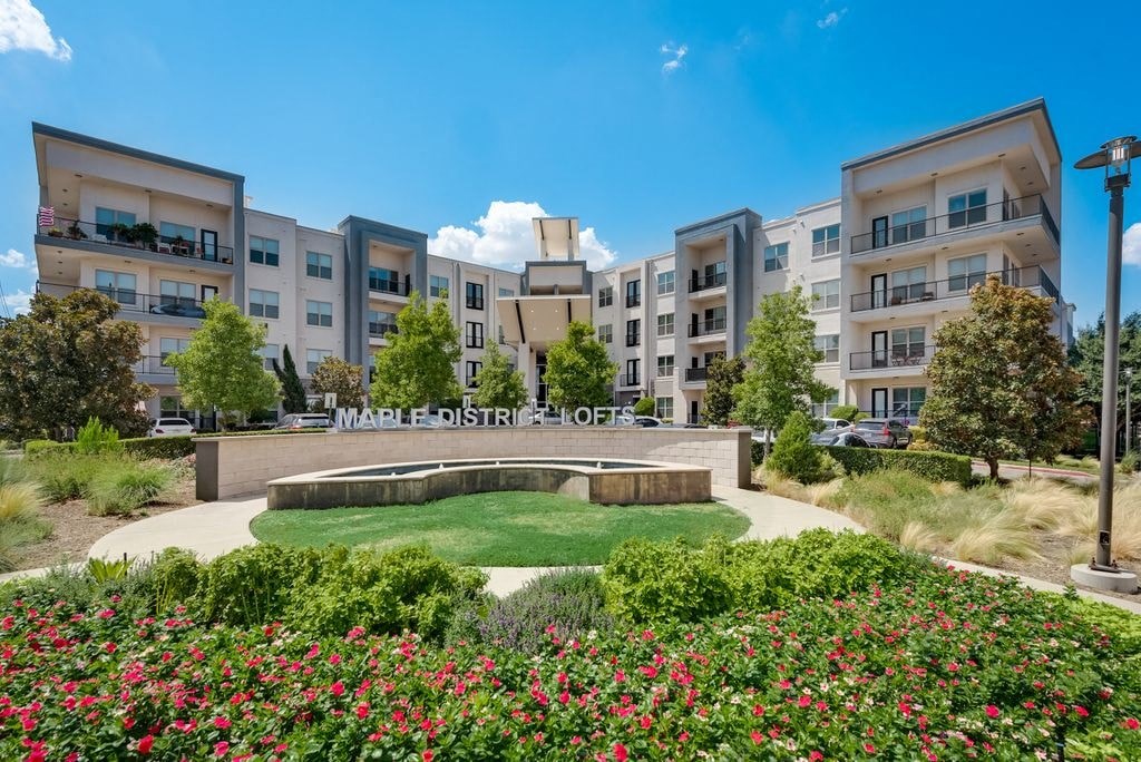 a park with a fountain in front of an apartment building