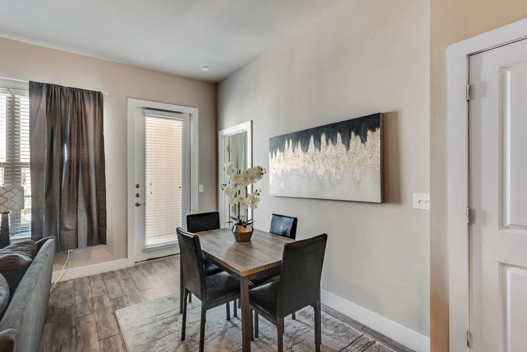 a dining room with a table and chairs and a window