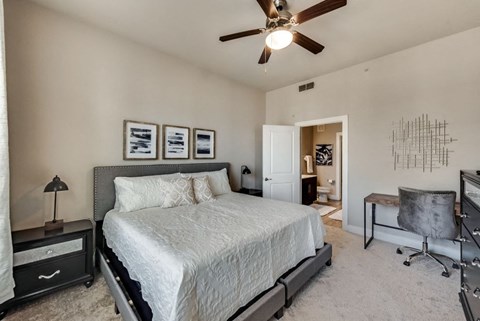 a bedroom with a large bed and a ceiling fan