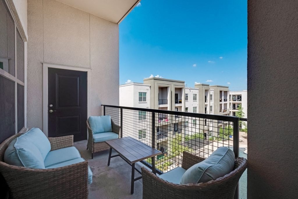 a balcony with a table and chairs and a patio