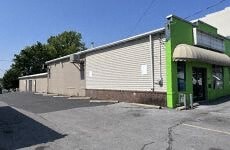 a green and white building on the side of a street