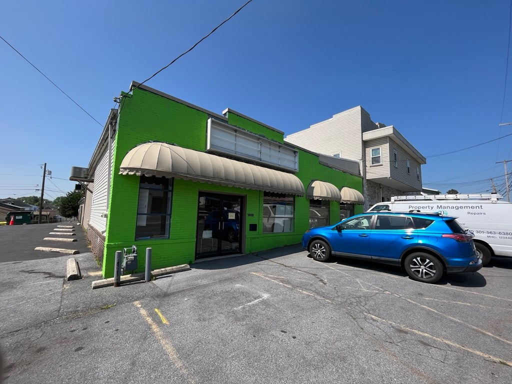 a green building with a blue car parked outside