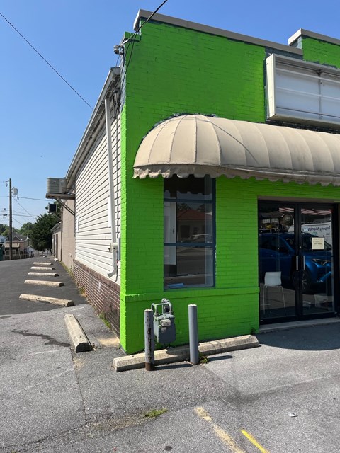 a green building on the side of a street