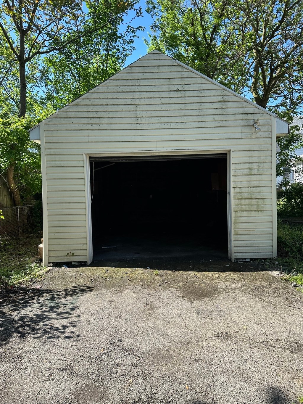 a small white garage with the door open