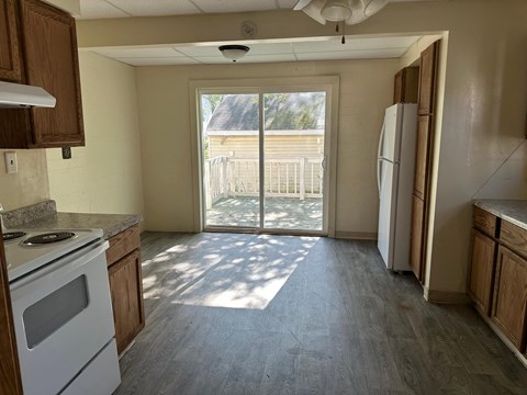 a kitchen with a white stove and a sliding glass door