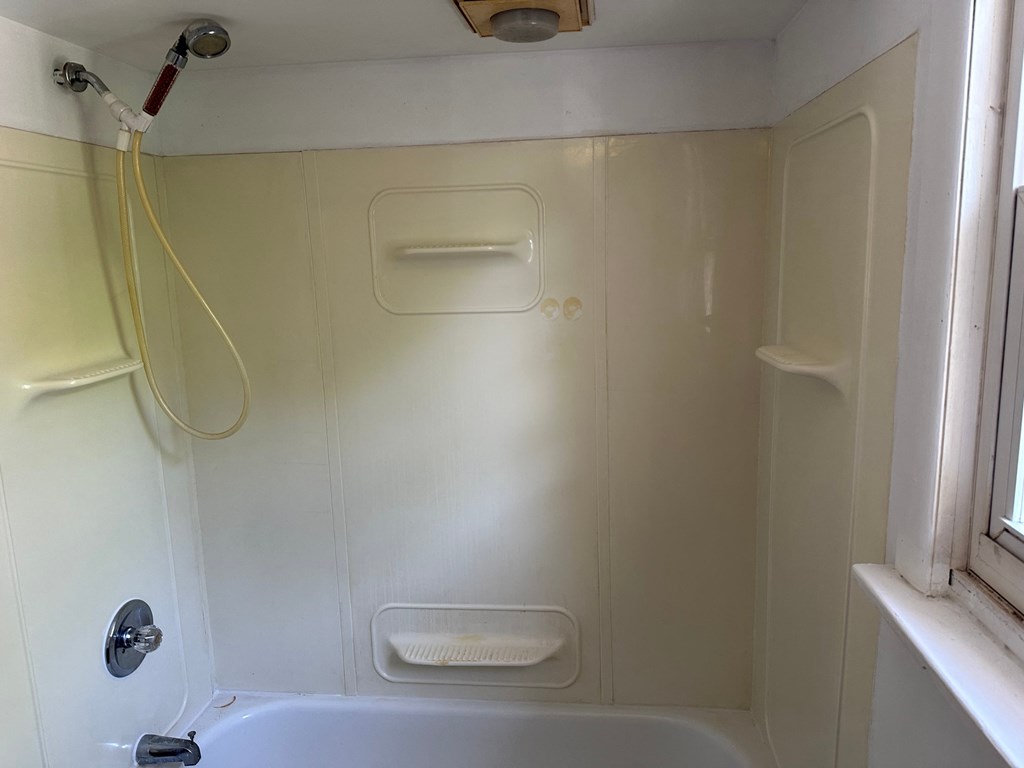 a small bathroom with a shower and a bath tub